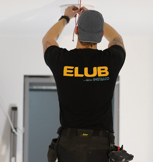 Bild på en elektriker som drar el med en Elub-tröja på sig. Elub är din proffsiga elektriker i Växjö